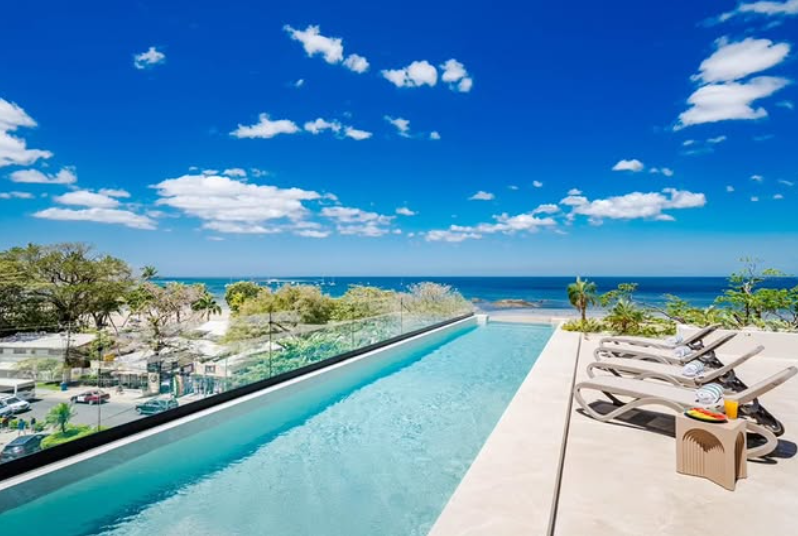 Naia rooftop pool, wide daytime view over Tamarindo Bay